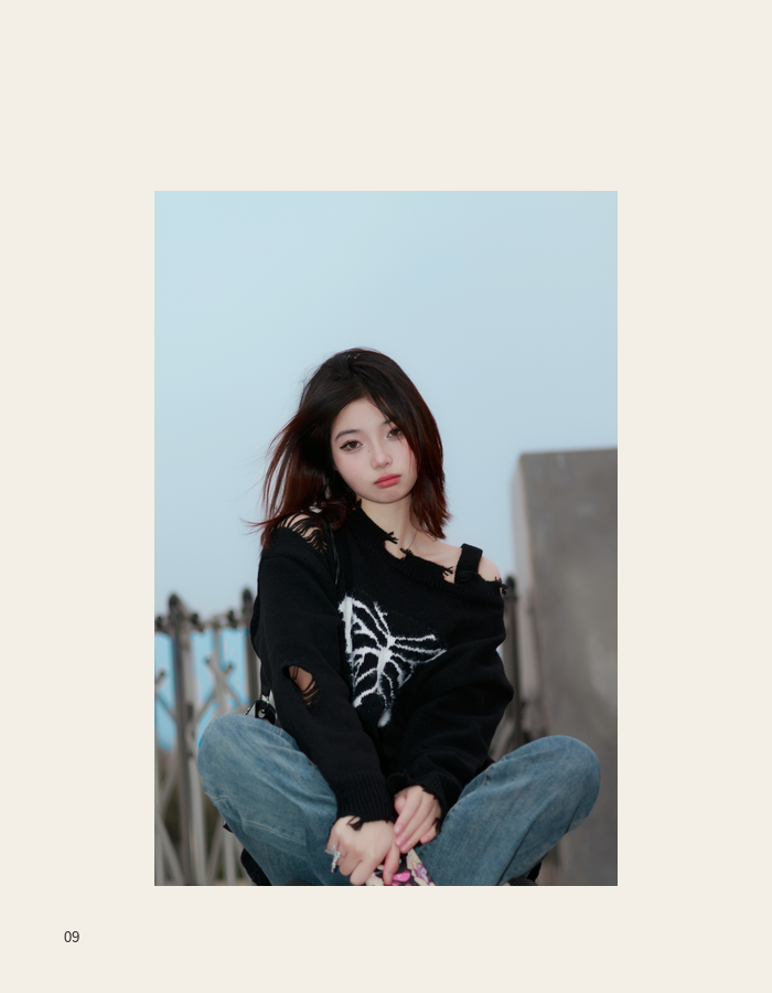 Seated black outfit portrait outdoors