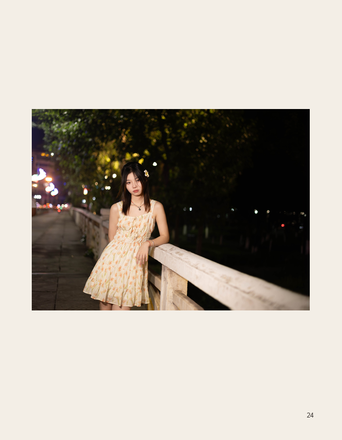 Floral dress portrait beside a glowing night railing