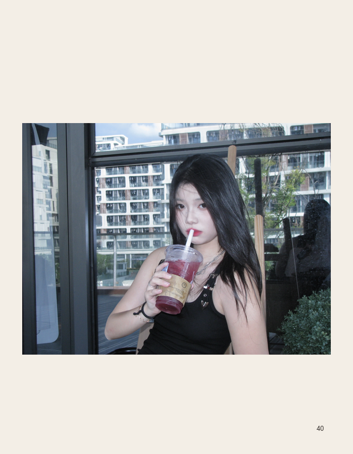 Portrait holding a drink beside a window