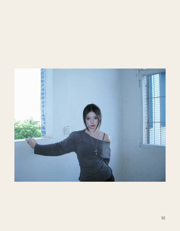 Figure posed in a blue room by an open window