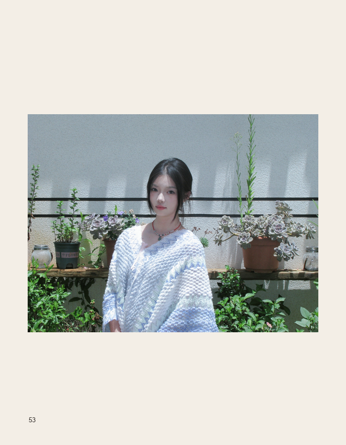 Garden portrait in a pale blue sweater